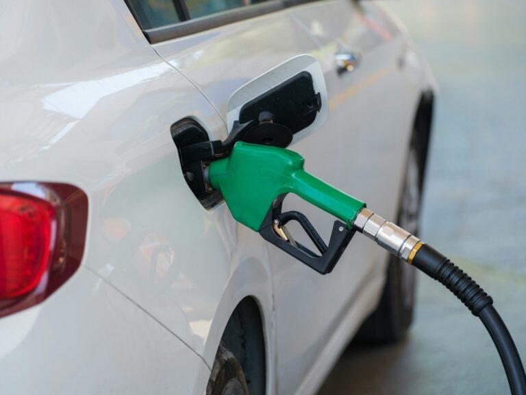 a white car with a green petrol pump